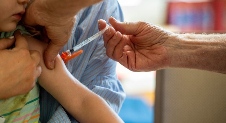 A child is given a vaccine in the arm