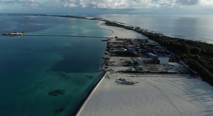 a coastline showing a large stretch of sandy beach seen from above