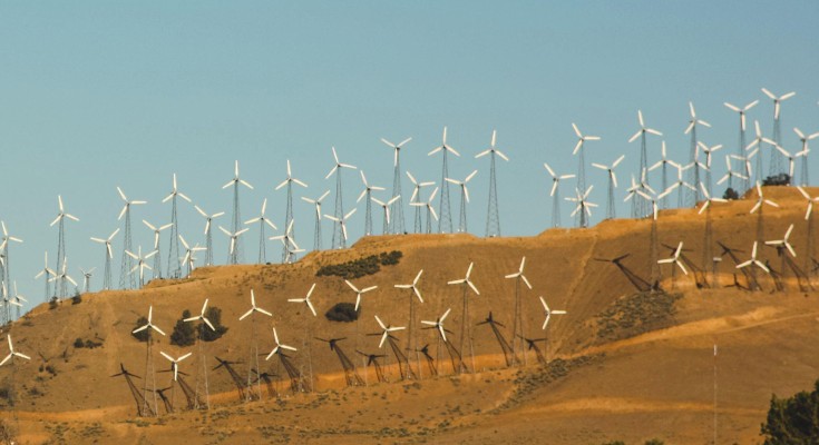 Wind farm on a hill in close proximity to a house