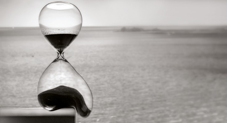 An hourglass melts as an illustration of material time.