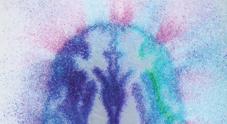 An image of a brain slice, made from diffuse multicoloured specks reminiscent of sand on a speaker. It represents the large and diverse datasets that the GNPC have harmonized together to provide a clearer understanding of the human brain. 