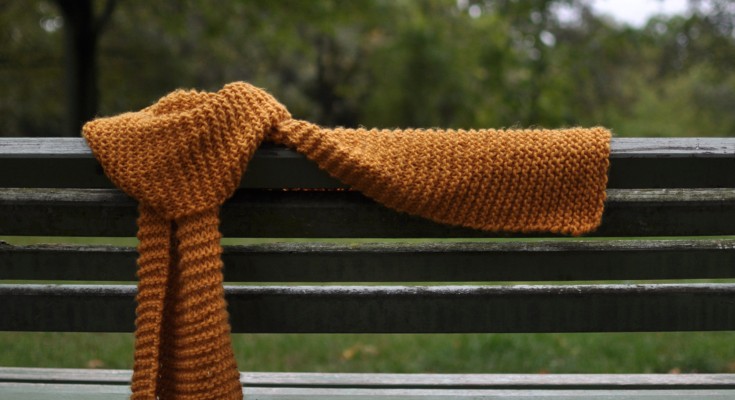 A knitted scarf on a bench