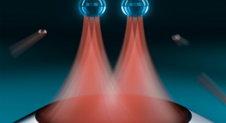artististic rendering of two trapped nanoparticles whose motion has been simultaneously cooled through precise shaking of laser beams