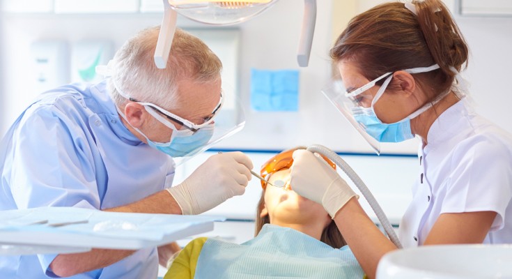 Dental professionals working in patient's mouth