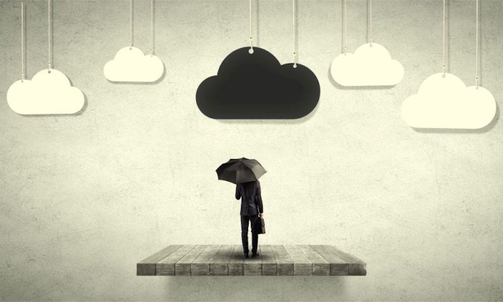 Manager steht mit Regenschirm unter einer dunklen Wolke.